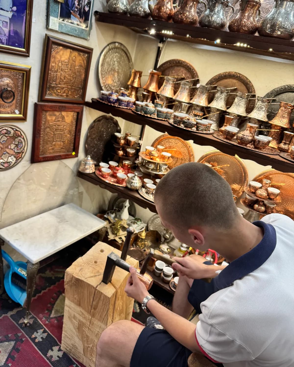 A person using hand tools at a metalworking bench in Sarajevo's Baščaršija.